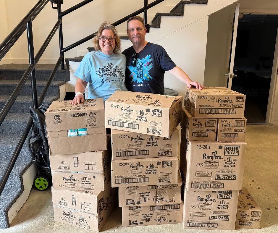 man and woman standing behind a few stacks of boxes
