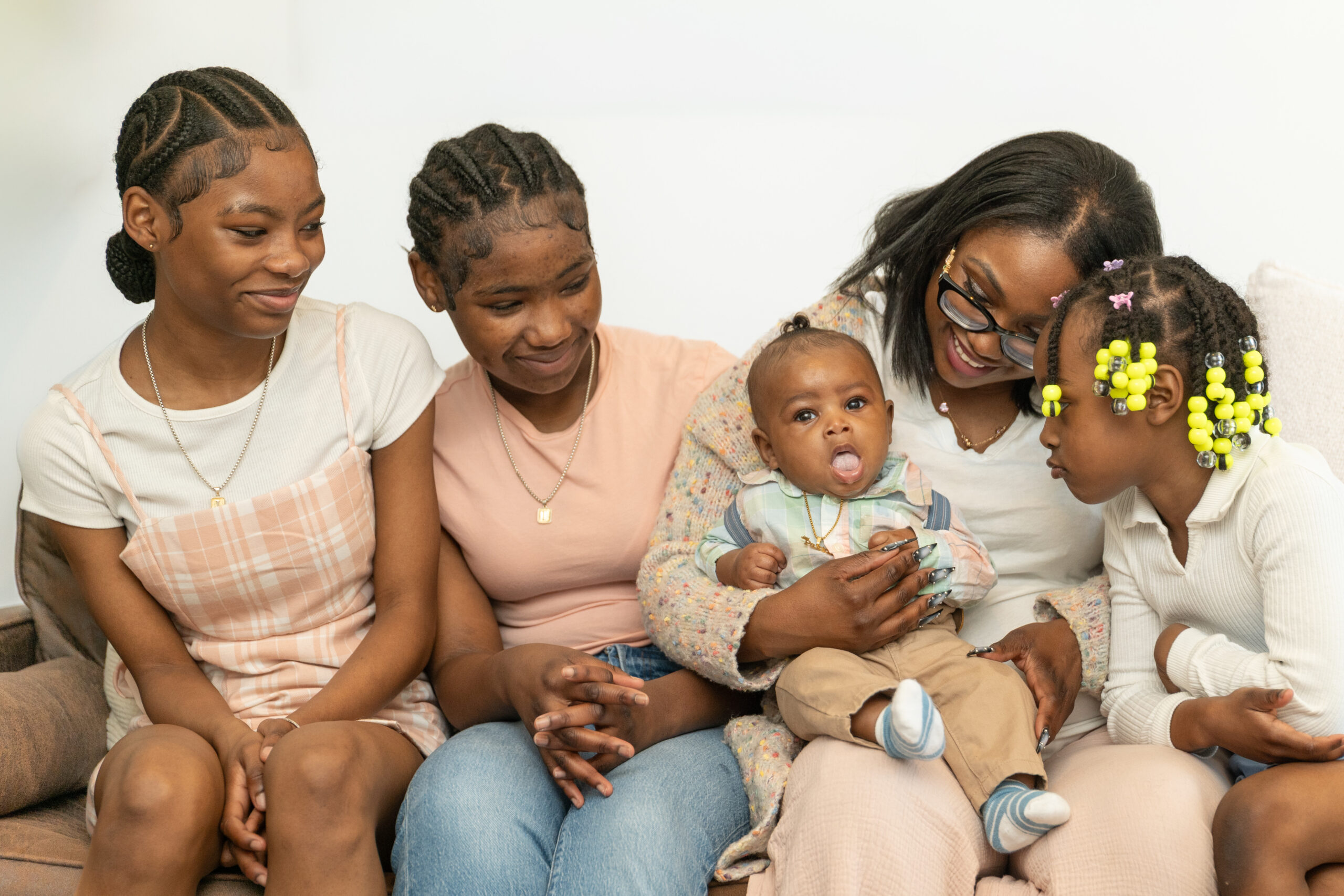 Family on a couch. Mom with three girls and one baby boy.